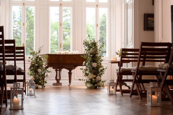 Piano forte in elegant manor house room ceremony setting wooden chairs